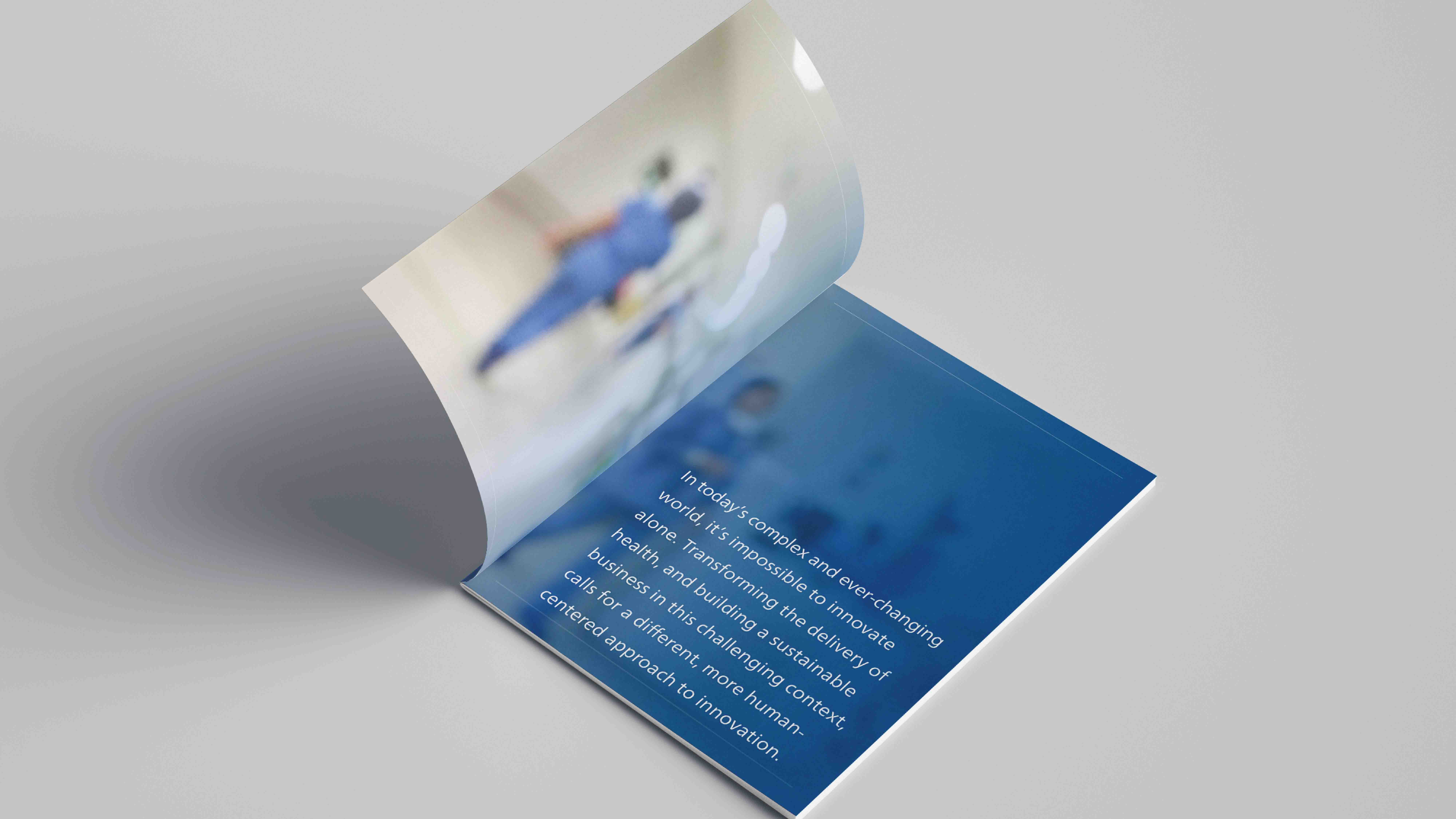Booklet on gray background. Opened to the first page. First page has typeogrpahy and image of nurse walking away. The color Blue is prominent. Booklet was made in Adobe illustrator and Adobe Indesign